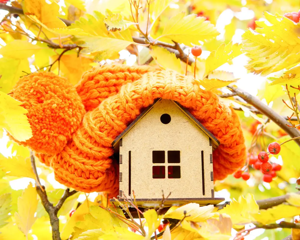 a small house in a tree with a bobble hat on - symbolic of loft insulation
